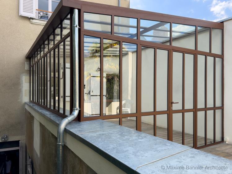 vue extérieur verrière verrière acier sur mesure reposant sur le mur maçonné.