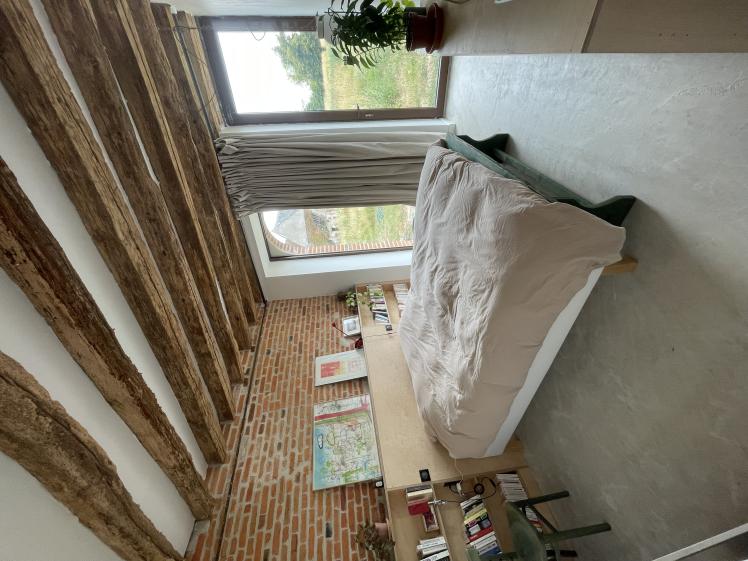 chambre avec tete de lit en bois dans une grange transformée en maison d'habitation
