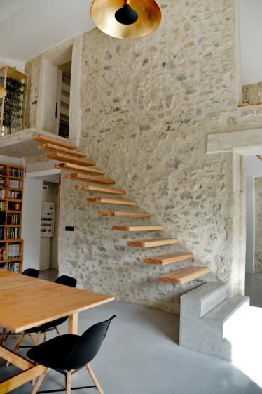 Escalier bois en porte à faux dans un mur pierre 