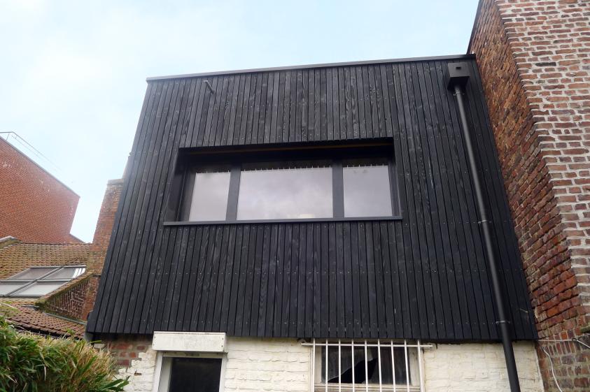 Extension par surélévation au dessus d'un garage en ossature bois - Bardage bois brûlé - Menuiseries Alu dont Châssis accordéon  - Toit terrasse accessible par un châssis de toit et escalier échelle bois