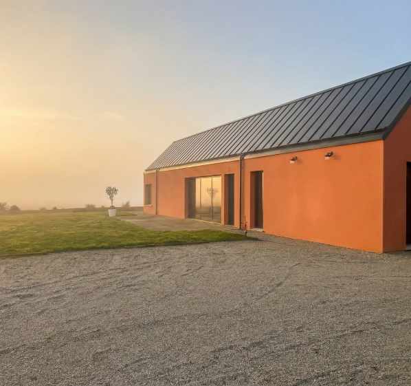 Cette maison individuelle développe une architecture sobre et durable, conçue en dialogue avec le paysage. Les volumes simples et les larges ouvertures favorisent la lumière naturelle et prolongent les espaces de vie vers le jardin, pour un cadre de vie confortable et adapté aux usages actuels.
