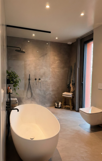 La salle de bains est pensée comme un lieu de bien-être, aux lignes épurées et aux matières douces. La baignoire îlot, associée à une douche ouverte et à la lumière naturelle, crée une atmosphère apaisante, propice au confort et à l’usage quotidien.