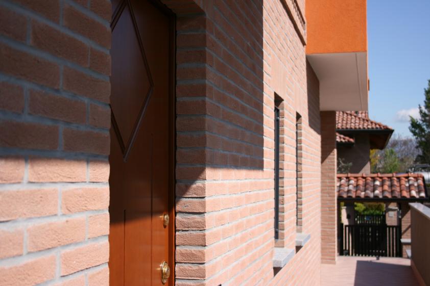 Détail entrée : brique apparente et menuiserie bois