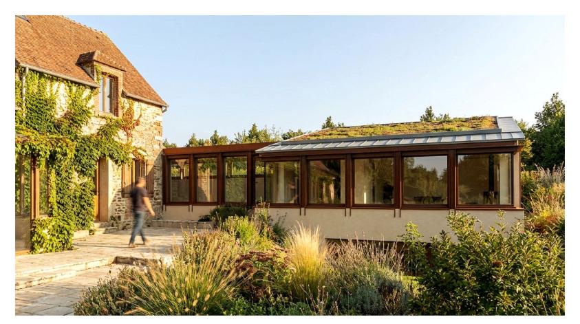 Vue de extension depuis le jardin, bâtiment légèrement encaissé dans le sol, en respect de la bâtisse principale