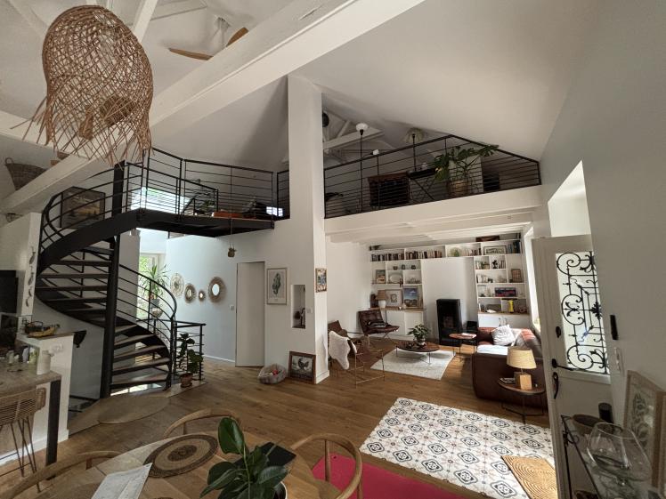 Vue intérieure de l’espace de vie – escalier hélicoïdal, mezzanine et salon en alcôve