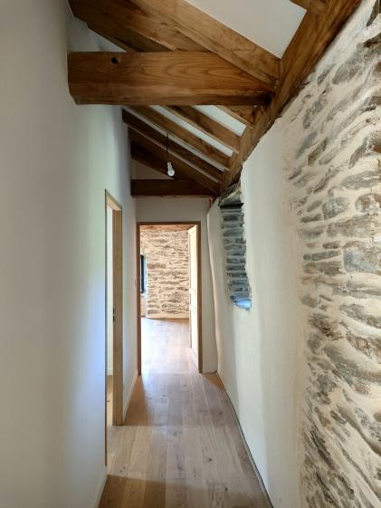 Circulation et matière Dialogue entre pierre apparente, enduit clair et parquet bois pour une circulation douce et lumineuse.