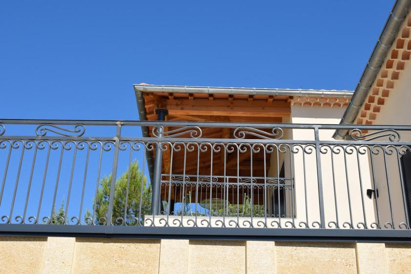 Création d’une terrasse avec garde-corps métallique et charpente apparente, mettant en valeur les matériaux et les proportions de l’ouvrage.