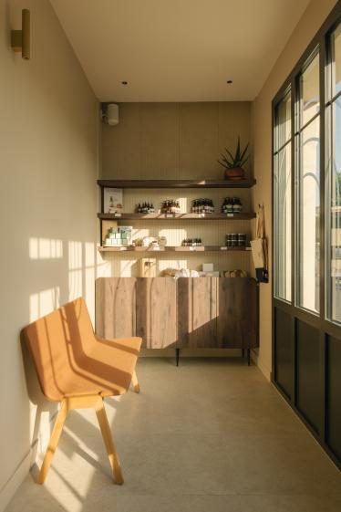Espace d’accueil et de vente du spa BEROA conçu par Eraiki.studio à Arcachon, associant bois naturel, teintes sable, mobilier sur mesure et ambiance apaisante inspirée du littoral.