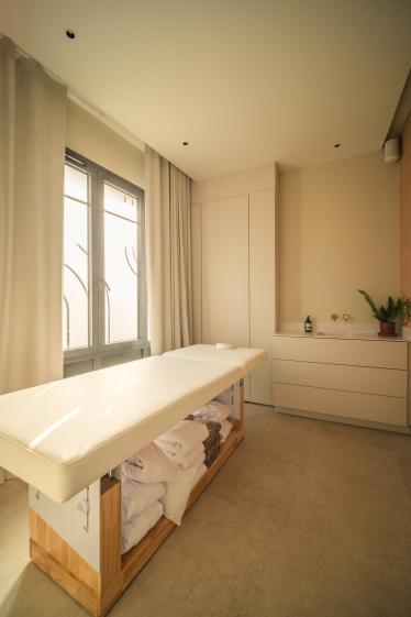 Cabine de massage du spa BEROA réalisée par Eraiki.studio à Arcachon, associant teintes sable, matériaux naturels, mobilier sur mesure et lumière douce pour une expérience de bien-être haut de gamme.