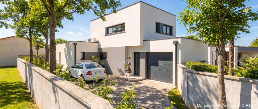 Vue depuis l'accès maison contemporaine avec volumes épurés en maçonnerie blanche