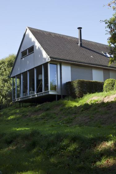 Maison en porte-à-faux vers l'espace boisé