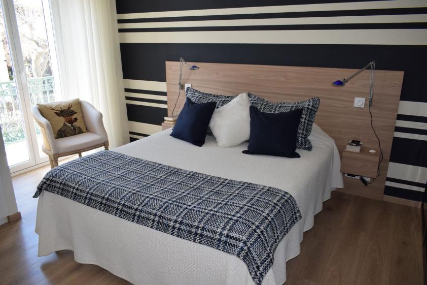 Vue d’ensemble de la chambre rénovée, structurée par un travail graphique bleu blanc et une ambiance contemporaine élégante.