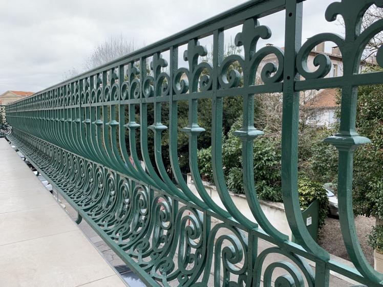 Détail de ferronnerie conservé et restauré, révélant le caractère patrimonial du lieu.