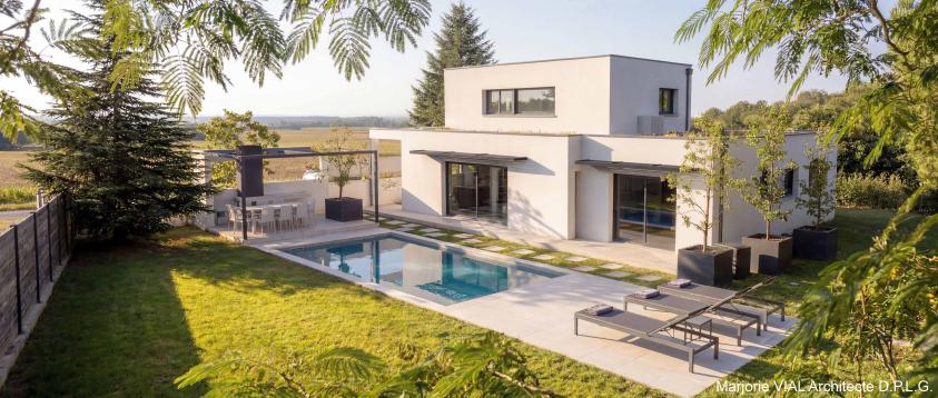 Volumes épurés blancs, toits végétalisés, piscine et poolhouse, vus depuis le jardin
