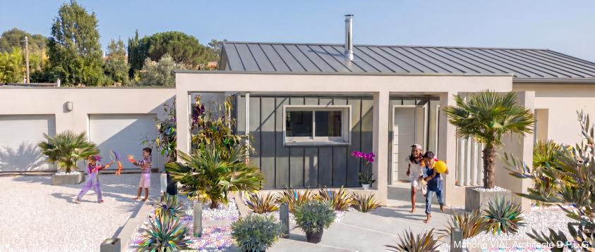 Parterre minéral végétalisé et portique béton rapportés devant la maison
