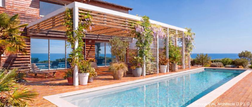 piscine et salon couvert en métal blanc et claustra bois