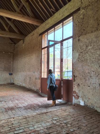 En réunion de chantier, observations sur la porte de la grange, sol en cours de restauration