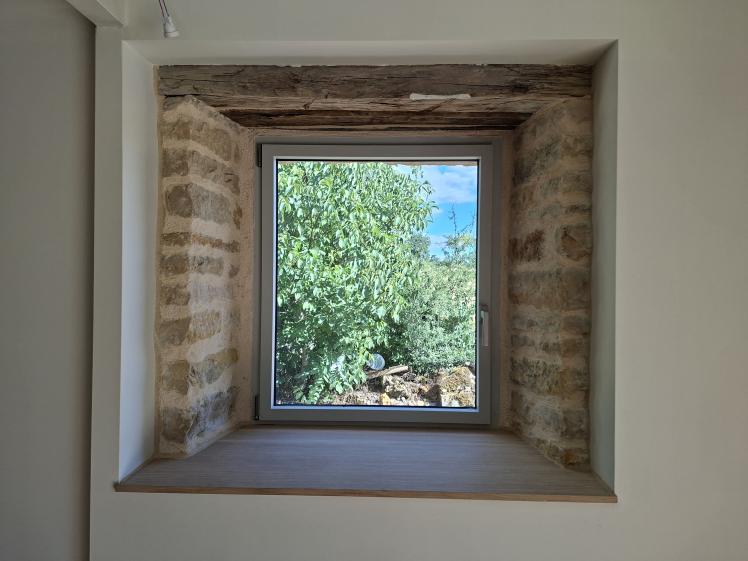 Pierres apparentes maintenues autour de la fenêtre, linteau en bois et tablette en chêne pierre apparente autour de la fenêtre