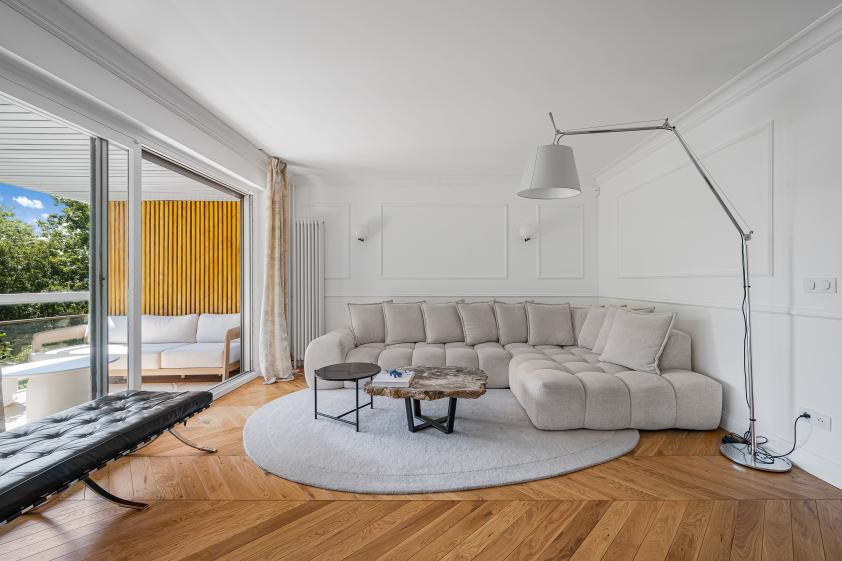 Salon haussmannien et parquet en point de Hongrie Salon lumineux rénové avec parquet en point de Hongrie, moulures et grandes fenêtres dans un appartement à Saint-Germain-en-Laye.