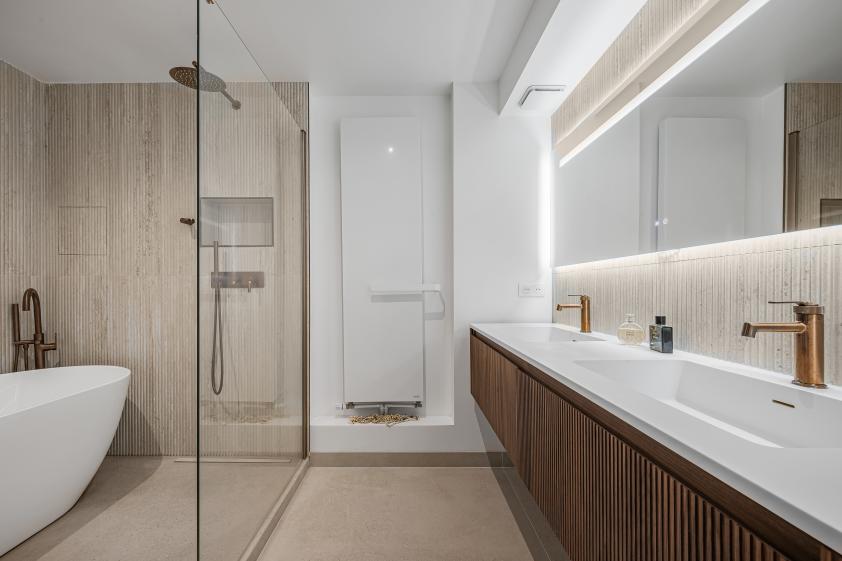 Salle de bain parentale – Aménagement sur mesure Vue d’ensemble de la salle de bain parentale rénovée, avec baignoire, meuble vasque sur mesure et finitions contemporaines.
