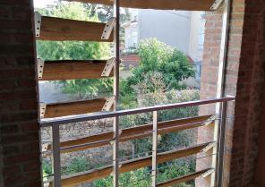 Vue sur l'extérieur à travers un brise vue en bois du site récupéré