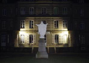 La façade du bâtiment château est mise en valeur par une lumière en pied