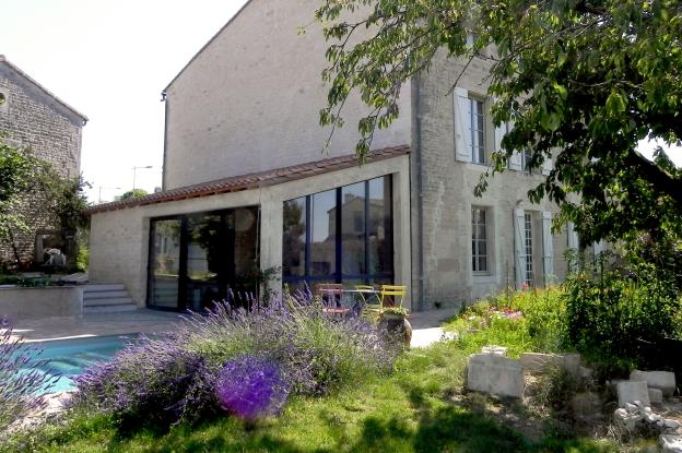 L'extension de la maison en pierre est constituée d'une veranda (partie salle à 