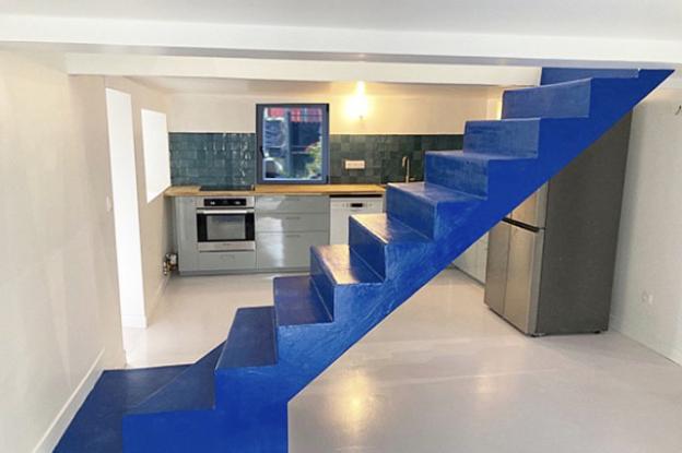 vue de la salle à manger sur cuisine ouverte et escalier béton