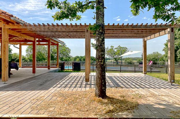 Rénovation complète d'une ferme avec création de piscine par l'Atelier S, architecte basé à Toulouse : vue de l'abri créé au bord de la piscine avec la pergola attenante pour manger à l'abri de la pluie ou du soleil 
