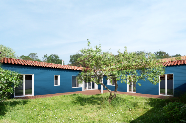 Vue de la maison depuis le jardin, bardage bois peint, terrasse bois, construction en rez-de-chaussée