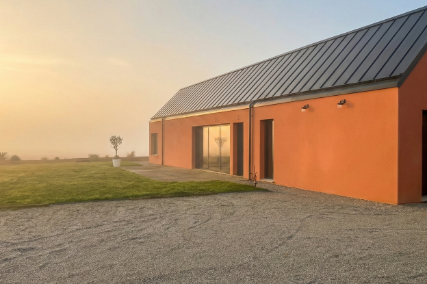 Cette maison individuelle développe une architecture sobre et durable, conçue en dialogue avec le paysage. Les volumes simples et les larges ouvertures favorisent la lumière naturelle et prolongent les espaces de vie vers le jardin, pour un cadre de vie confortable et adapté aux usages actuels.