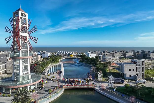 Tour belvédère panoramique rappelant un moulin rouge, située au centre de The Maris Vung Tau, avec café au rez-de-chaussée, la terrasse adjacente en forme de proue de bateau et pont adjacent