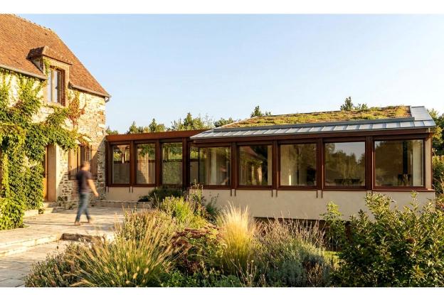 Vue de extension depuis le jardin, bâtiment légèrement encaissé dans le sol, en respect de la bâtisse principale
