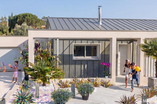 Parterre minéral végétalisé et portique béton rapportés devant la maison