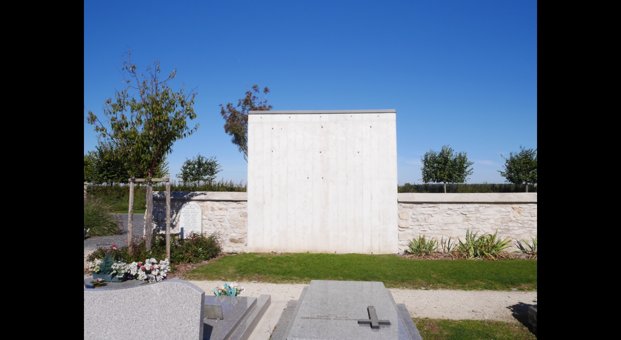 Local cimetière: Mur sobre en béton coffré dans le mur en pierre existant