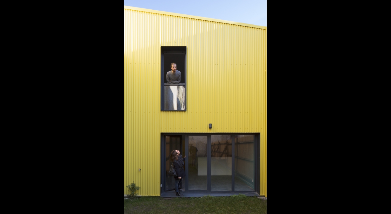 Une des maisons du projet est habillée par du bardage métallique jaune qui illumine le cœur de la parcelle. Projet Triptyk / whyarchitecture