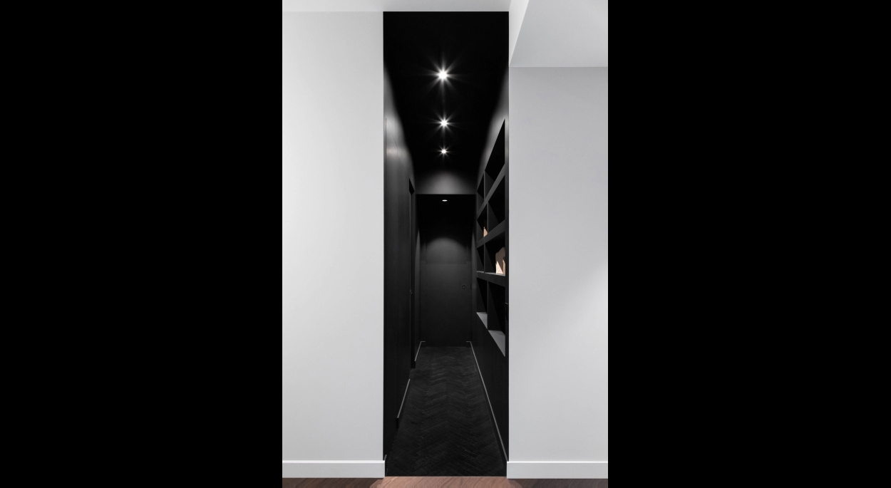 Couloir noir séparant les pièces privées des espaces de vie
