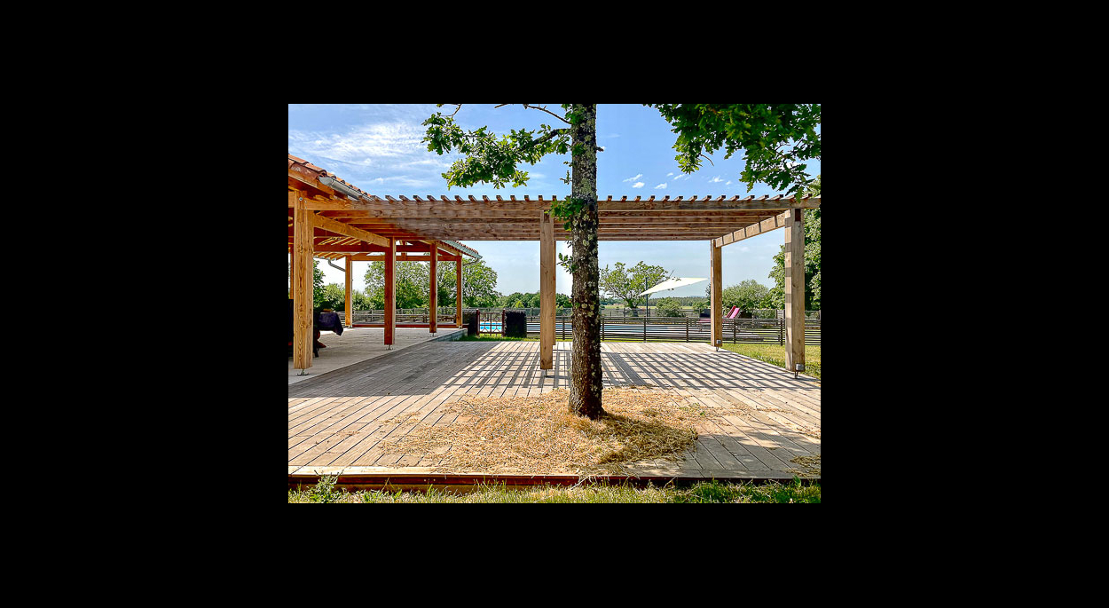 rénovation d'une ferme dans le Tarn et Garonne par l'atelier architectures, architecte à Toulouse. Terrasse bois avec pergola au bord de la piscine