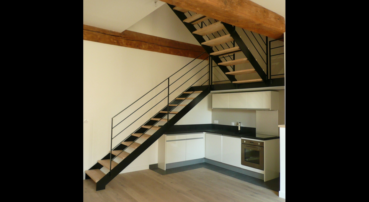 Un escalier conçu en 2 volées, accueillant la cuisine sous son palier