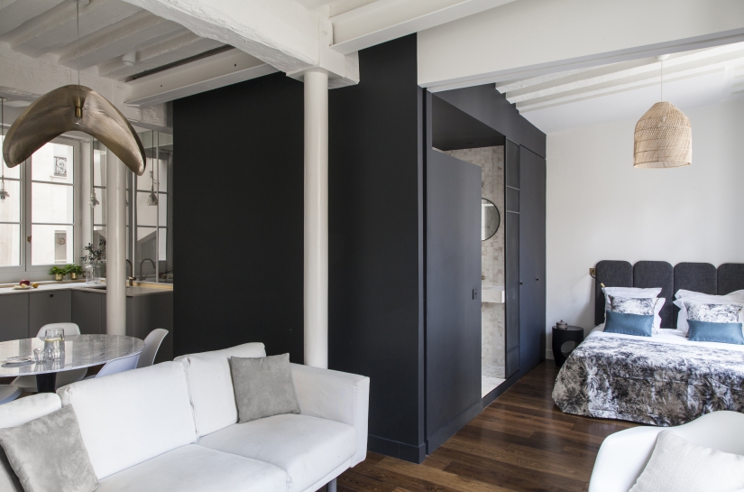Les espaces s'organisent autour du cube noir. L'effet de contraste avec les murs blancs de l'appartement accentue la luminosité.