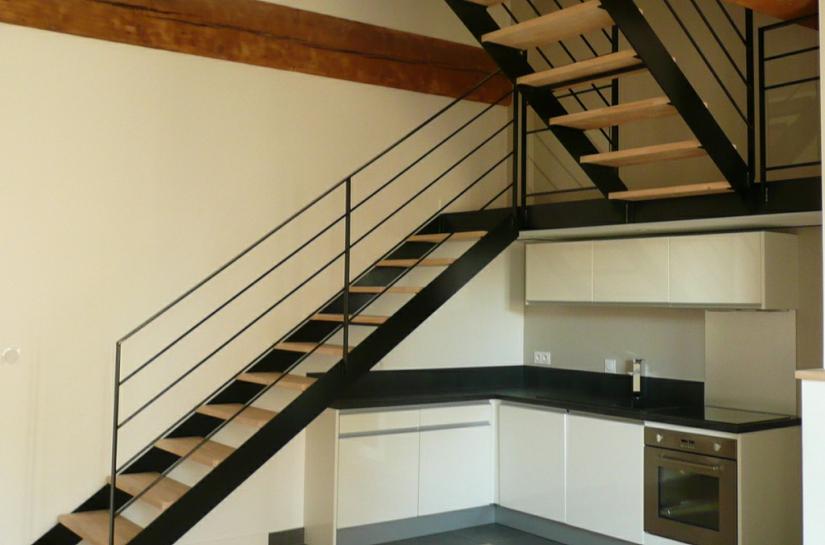 Un escalier conçu en 2 volées, accueillant la cuisine sous son palier